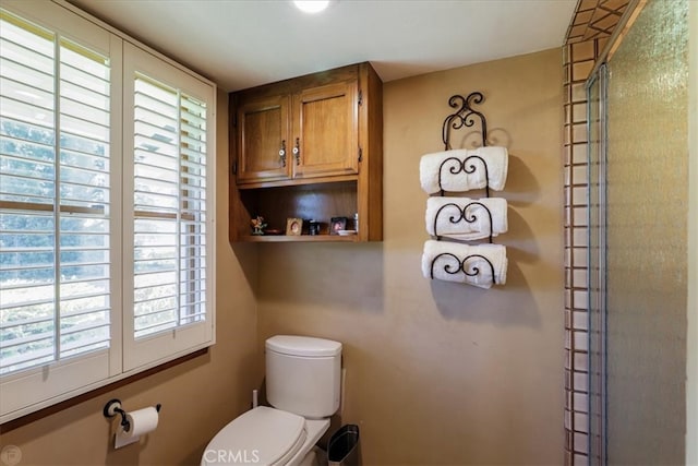 bathroom with toilet and a shower with shower door