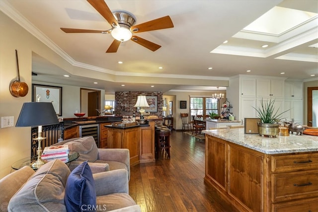 interior space featuring light stone counters, wine cooler, a kitchen island, dark hardwood / wood-style floors, and crown molding