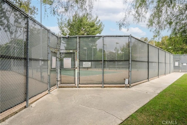 view of sport court with a gate and fence