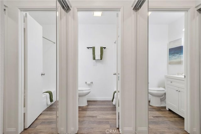 bathroom with vanity, wood finished floors, and toilet