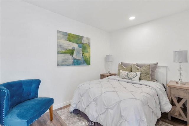 bedroom with baseboards, wood finished floors, and recessed lighting