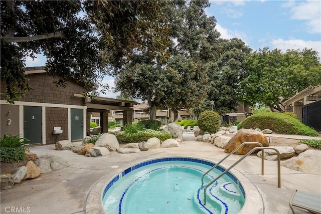 view of swimming pool with a hot tub