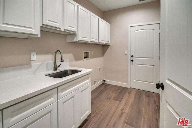 laundry room featuring washer hookup, sink, hookup for an electric dryer, cabinets, and light wood-type flooring