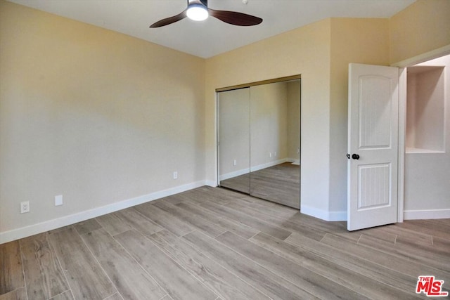 unfurnished bedroom with a closet, light wood-type flooring, and ceiling fan