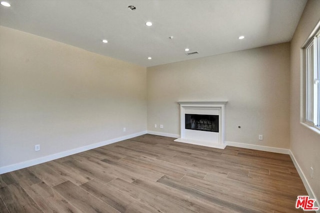 unfurnished living room featuring light wood-type flooring and a wealth of natural light