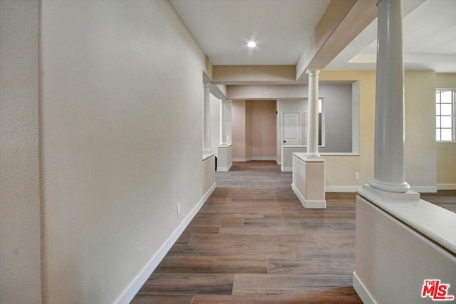 hallway featuring ornate columns and hardwood / wood-style flooring