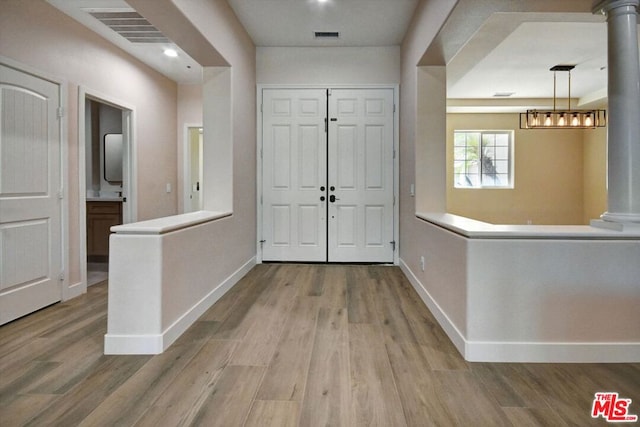 foyer entrance with ornate columns and wood-type flooring