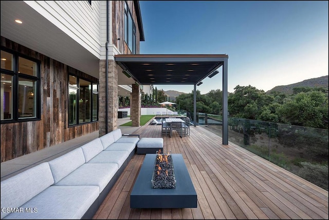 wooden deck with a mountain view and an outdoor living space with a fire pit