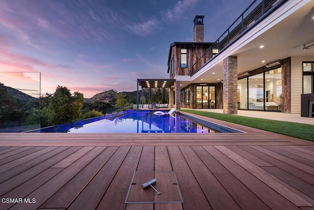 pool at dusk with a deck with mountain view