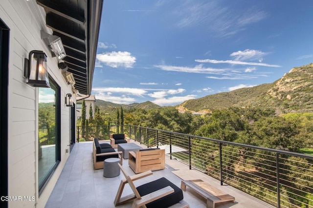 view of patio featuring a mountain view, outdoor lounge area, and a balcony