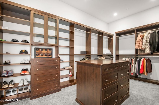 walk in closet featuring light carpet