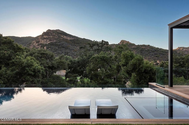 view of swimming pool with a water and mountain view