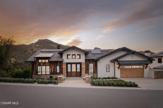 view of front of house with a mountain view and solar panels