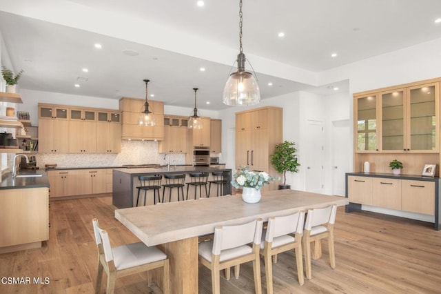 dining space with light hardwood / wood-style flooring and sink