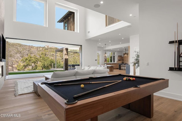 recreation room with a healthy amount of sunlight, a towering ceiling, and pool table