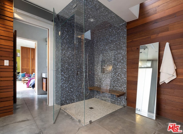 bathroom with a shower, wooden walls, and concrete flooring