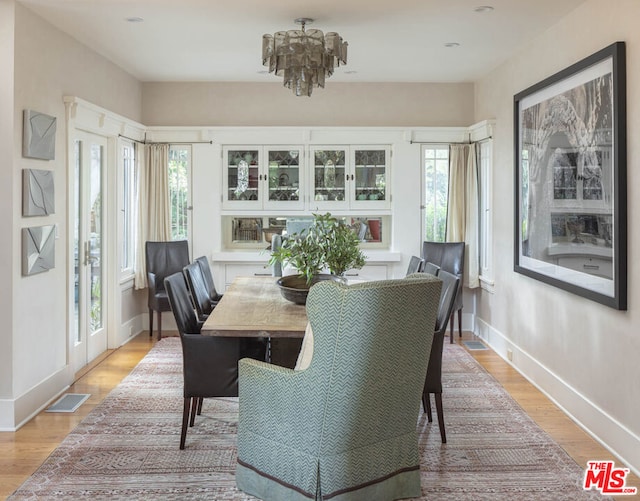 dining room featuring a chandelier, a wealth of natural light, and light wood-type flooring