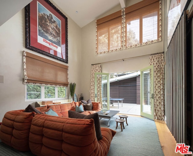 living room featuring high vaulted ceiling and carpet floors