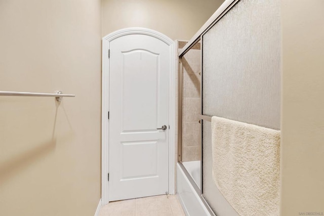 bathroom with tile patterned floors and shower / bath combination with glass door