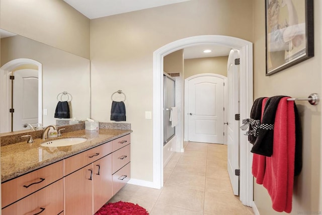 bathroom with vanity, enclosed tub / shower combo, and tile patterned floors