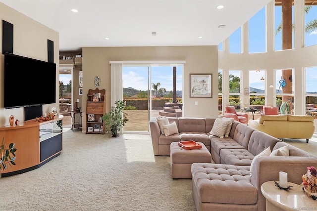 carpeted living room with a mountain view and a towering ceiling