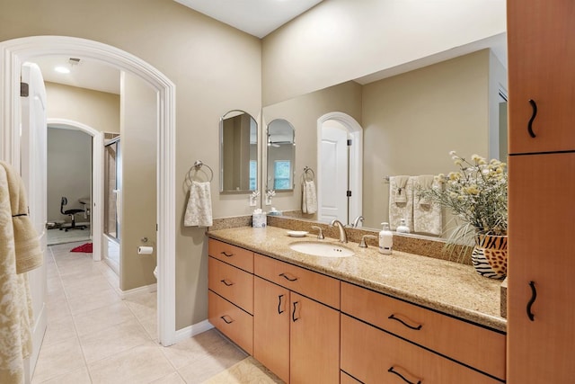 bathroom with a shower with door, vanity, toilet, and tile patterned floors