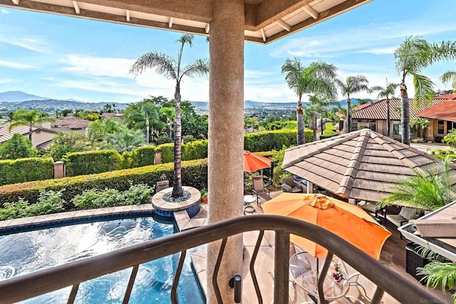 balcony featuring a mountain view and a patio area