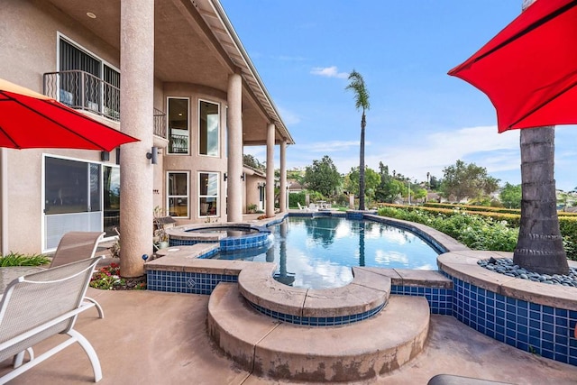 view of swimming pool with a patio and an in ground hot tub