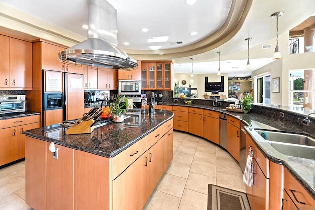 kitchen with island exhaust hood, decorative light fixtures, built in appliances, and backsplash