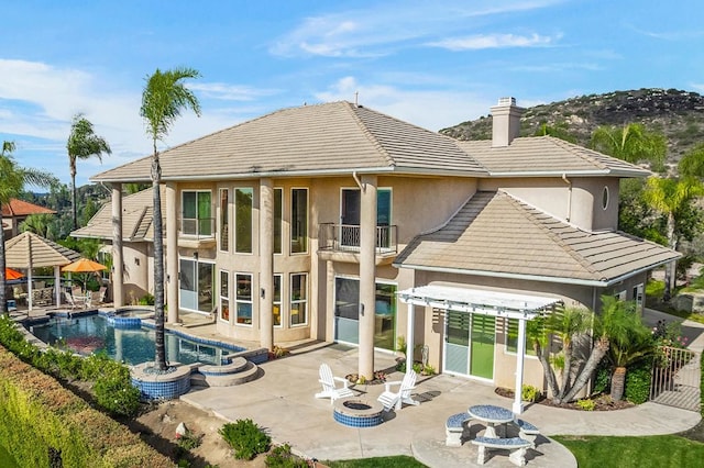 rear view of property featuring a patio and a balcony