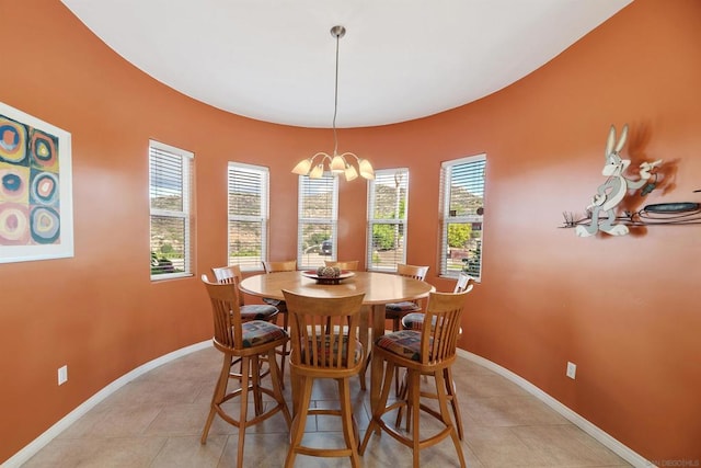 dining space with light tile patterned floors, a wealth of natural light, and an inviting chandelier