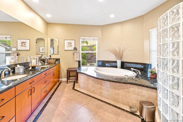 bathroom featuring vanity, tiled tub, and tile patterned flooring