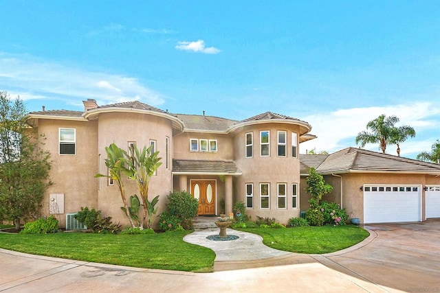 mediterranean / spanish home featuring central AC, a garage, and a front lawn