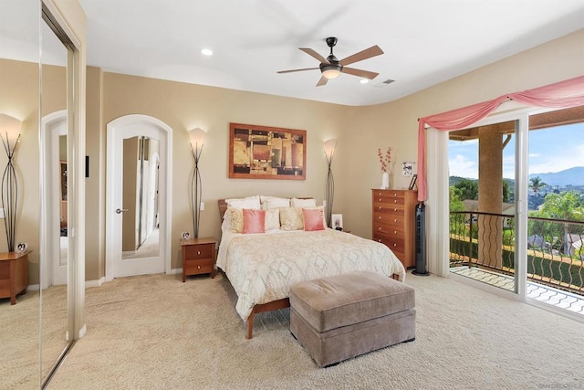 carpeted bedroom with a closet, ceiling fan, a mountain view, and access to exterior