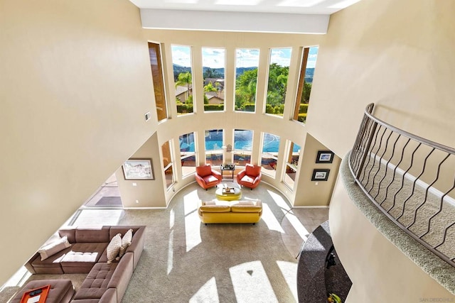 carpeted living room with a towering ceiling