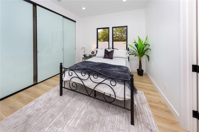 bedroom with light wood-type flooring and a closet