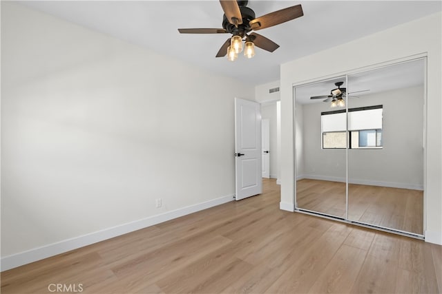 unfurnished bedroom featuring light hardwood / wood-style flooring, a closet, and ceiling fan