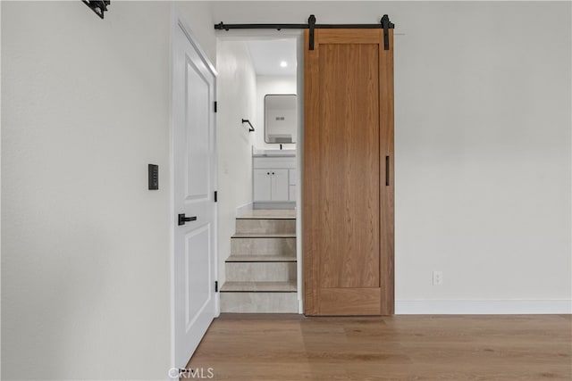 hallway featuring a barn door and light wood-type flooring