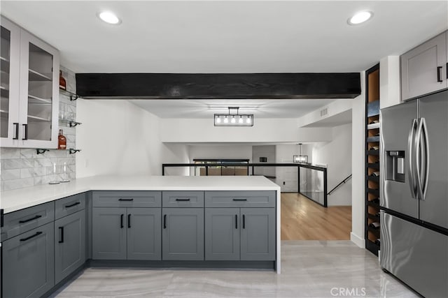 kitchen with beam ceiling, stainless steel fridge with ice dispenser, and gray cabinets