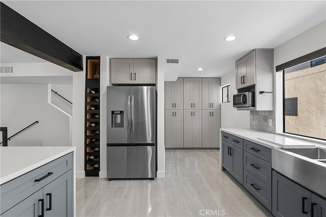 kitchen featuring appliances with stainless steel finishes, plenty of natural light, and gray cabinets