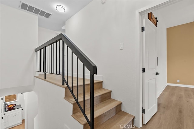 stairway featuring wood-type flooring