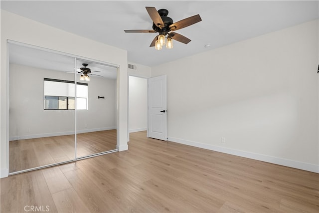 unfurnished bedroom featuring light hardwood / wood-style floors, a closet, and ceiling fan