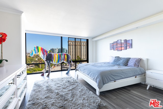 bedroom featuring hardwood / wood-style flooring, ornamental molding, floor to ceiling windows, and multiple windows