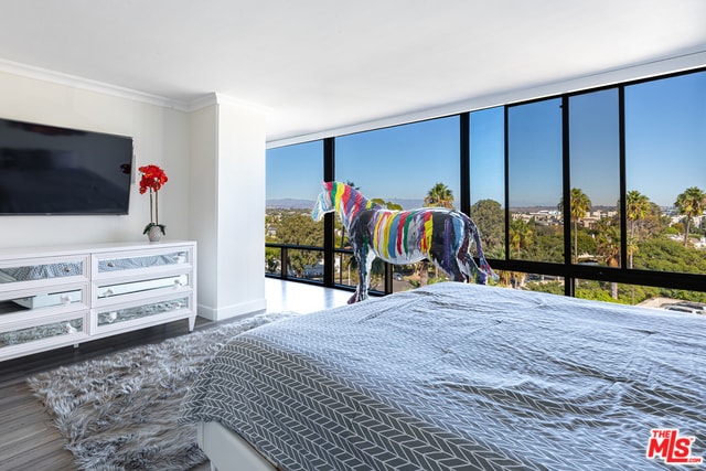 bedroom with ornamental molding and hardwood / wood-style floors