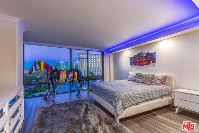 bedroom with ornamental molding, floor to ceiling windows, and wood-type flooring