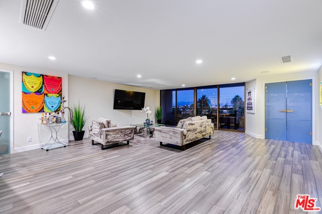 living room featuring light wood-type flooring and expansive windows