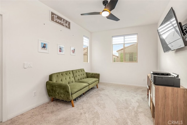 sitting room with ceiling fan and light colored carpet