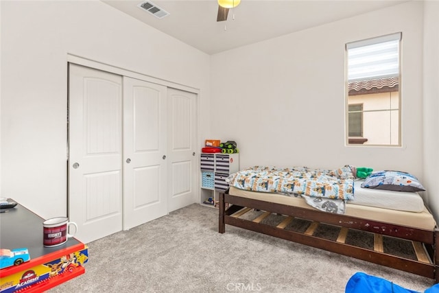 carpeted bedroom featuring ceiling fan and a closet