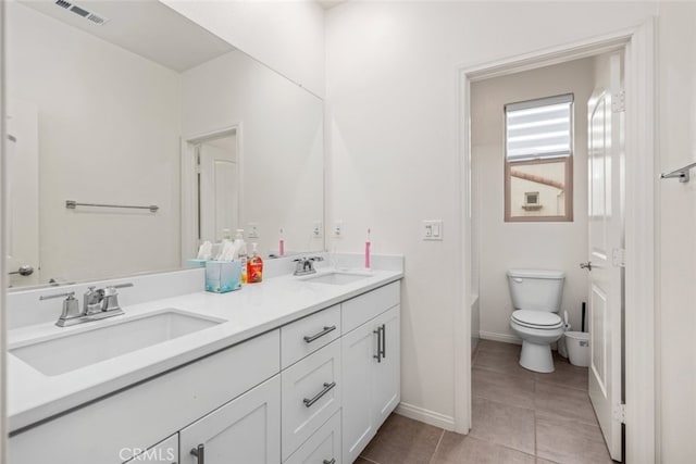 bathroom featuring tile patterned floors, a bath, vanity, and toilet