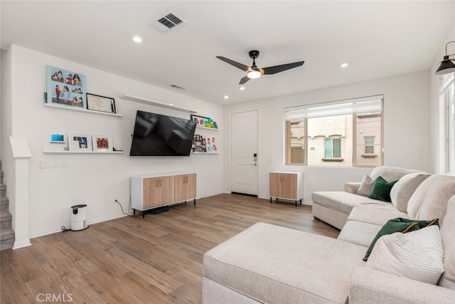 living room with radiator heating unit, light hardwood / wood-style floors, and ceiling fan